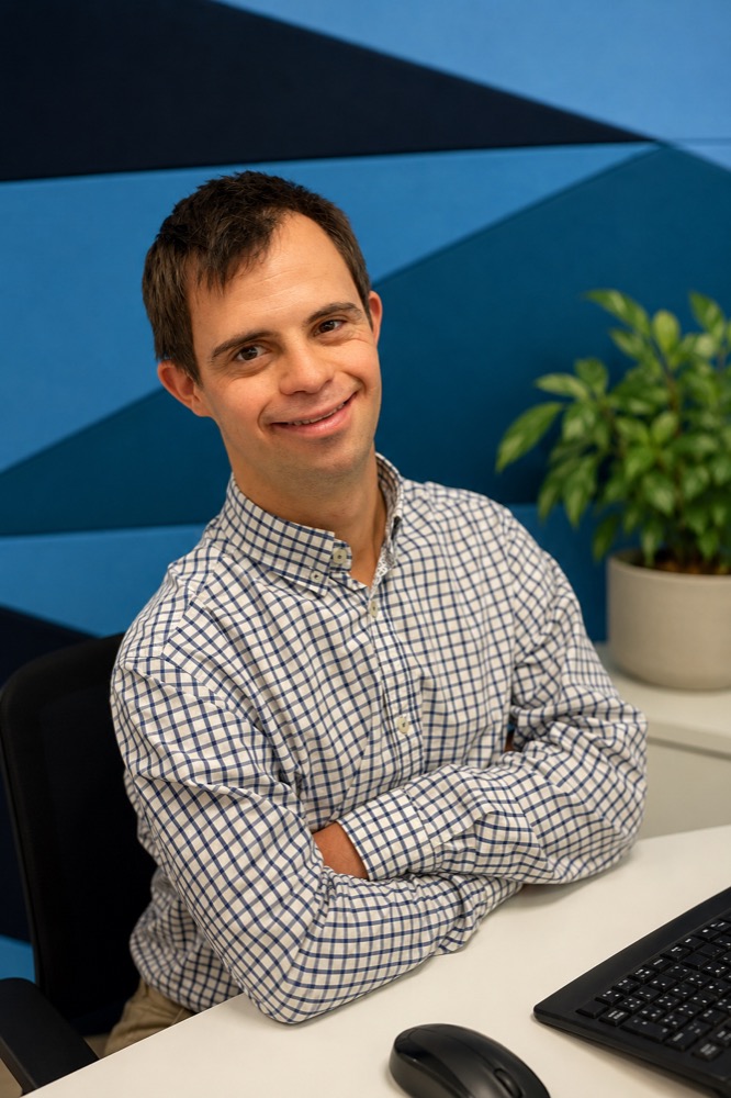 Professional in their workplace, smiling with arms crossed